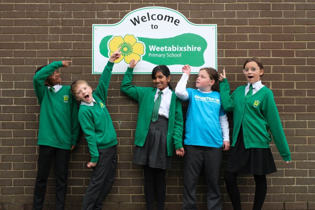 EDITORIAL USE ONLY Meadowside Primary school pupils (left to right) Junior, Theo, Esha, Lily, and Isabelle in front of a ‘Welcome to Weetabixshire’ sign which has been erected in the Northamptonshire town of Burton Latimer to mark the new proposed county lines of Weetabixshire. Picture date: Tuesday November 14, 2023. PA Photo. The breakfast cereal brand is petitioning to create a new county comprising a 50-mile radius from their Mills in Burton Latimer where all the wheat for the cereal is grown. Photo credit should read: Michael Leckie/PA Wire